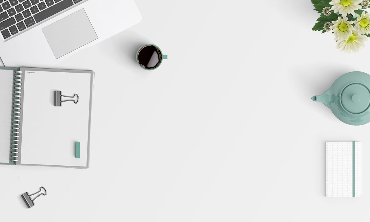 Home Clean minimalist workspace with a laptop, coffee, flowers, and stationery.